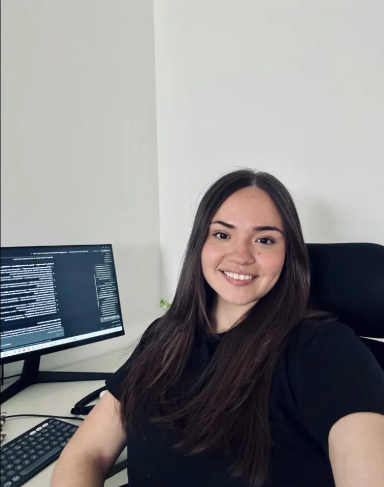 Joana Villarreal sentada frente a su escritorio, sonriendo a cámara